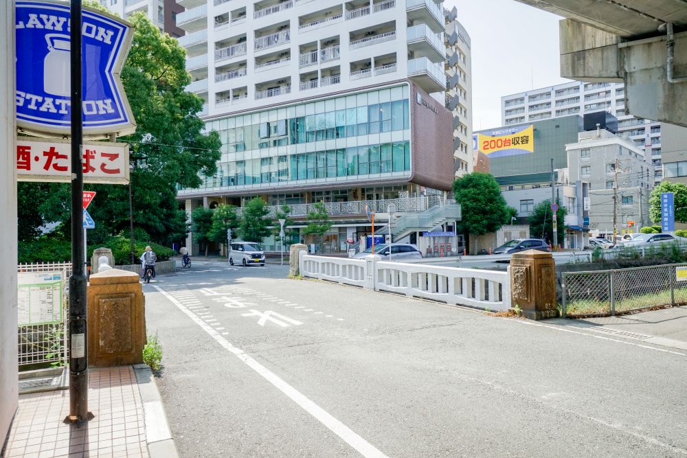 ローソンから左に曲がり橋を渡ると道を挟んだ真正面に見えるビル1階